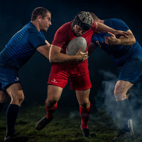 Rugby players competing in a tackle during a match