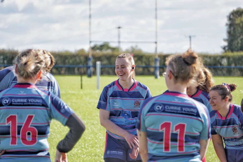 Women’s rugby players on pitch wearing custom team kit before play