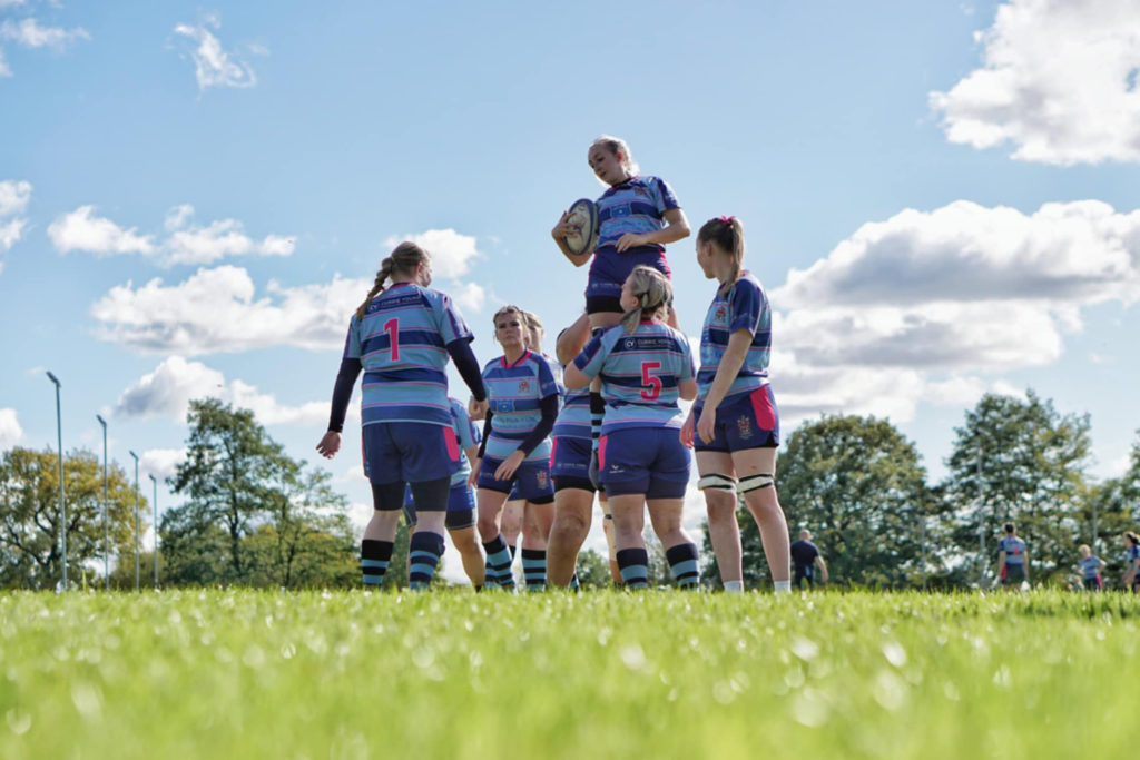 Women’s rugby lineout in custom blue and maroon rugby kit during match play