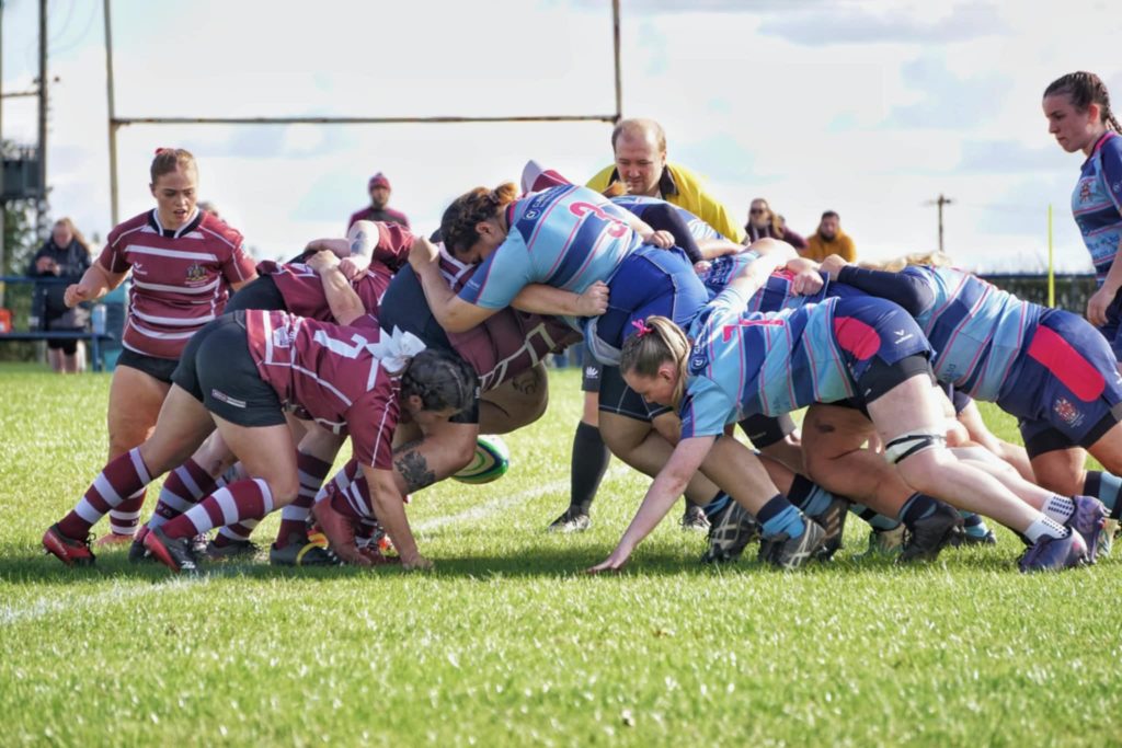 Women’s rugby scrum in custom rugby shirts during match play
