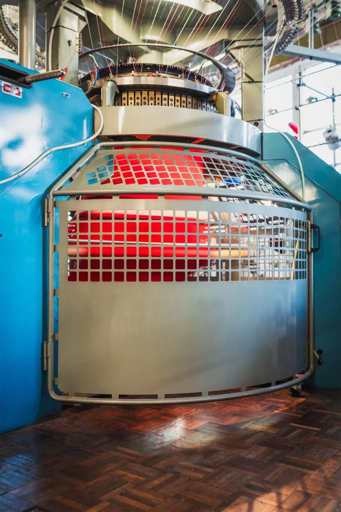 Circular knitting machine used in the production of custom sportswear fabrics.
