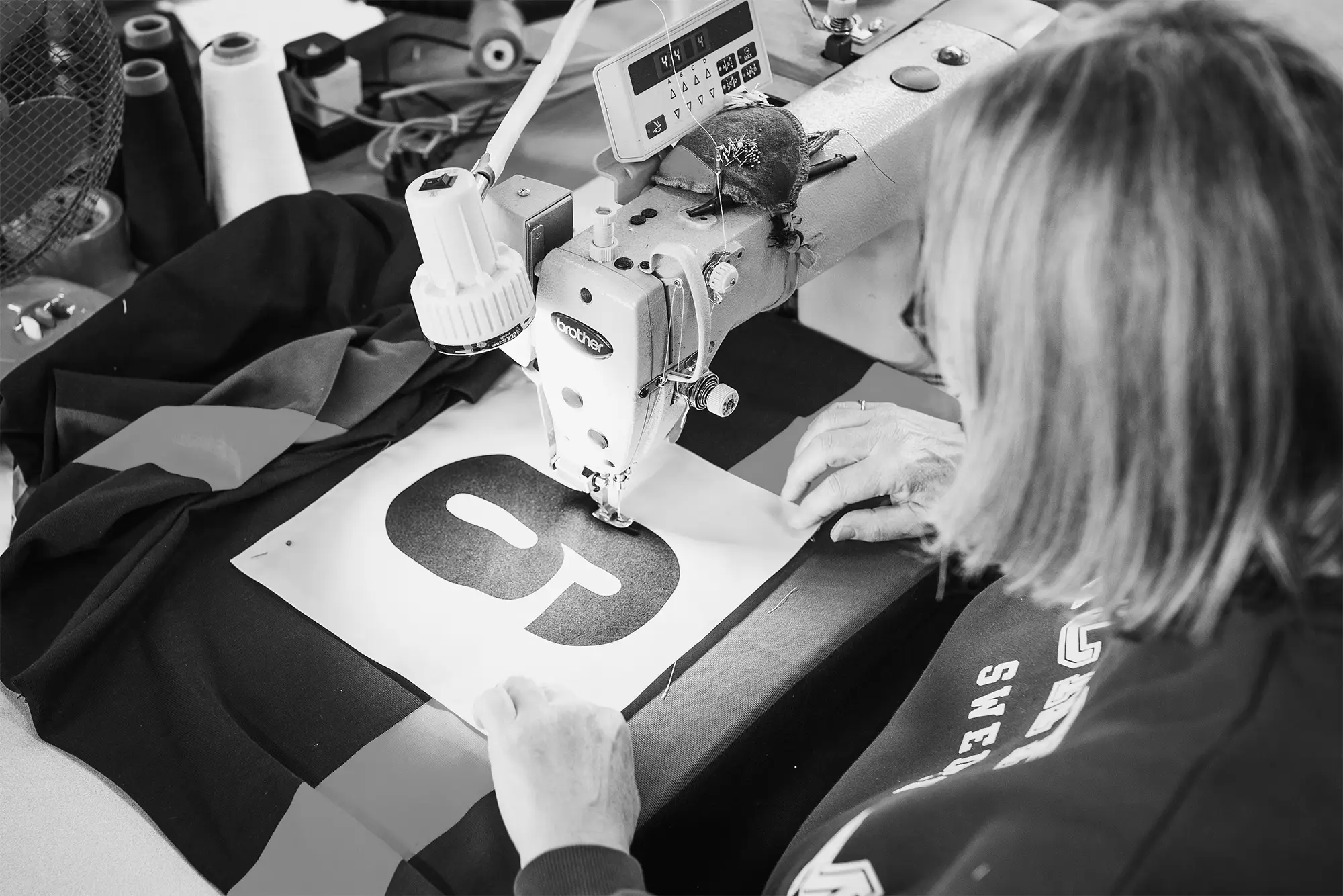 Vulcan Sports team member sewing a custom sports shirt in our UK factory