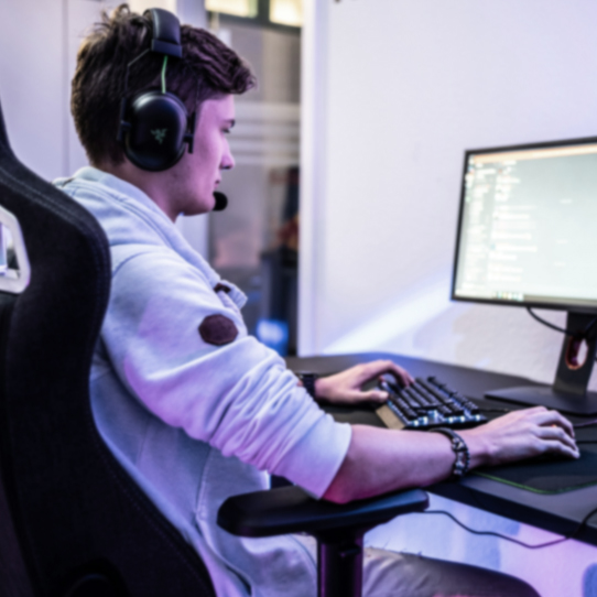 Esports player gaming at a PC while wearing a headset